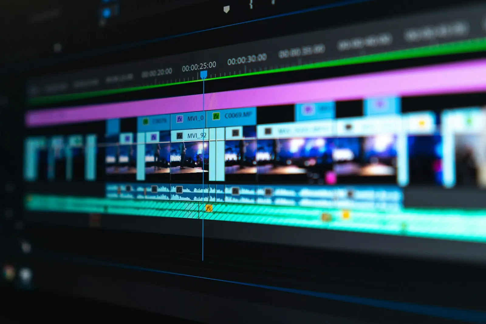 Video editing timeline with colour-coded clips on a monitor